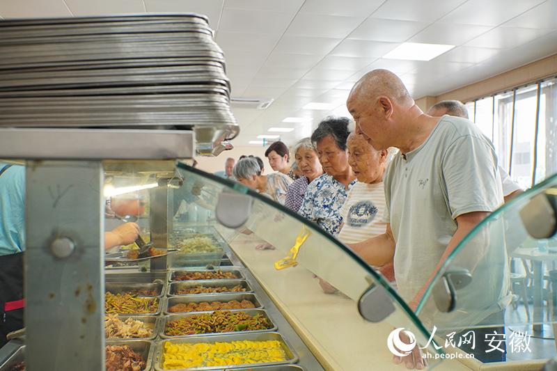 恒通社区老年食堂内，老人们正在排队打菜。人民网 陈若天摄