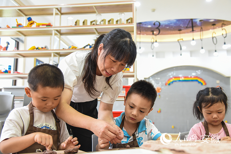 在老师的指导下，孩子们学习泥塑。人民网 李希蒙摄