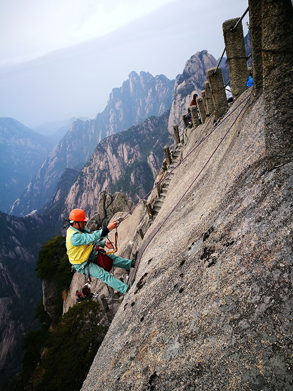 李培生在天都峰放绳索。 关碧瑶 摄