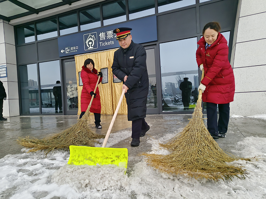 车站工作人员清扫售票厅和进站口积雪。宿州火车站供图