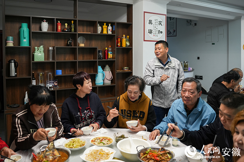 和坪山庄民宿负责人汪建同用餐的游客交流。人民网记者 王锐摄