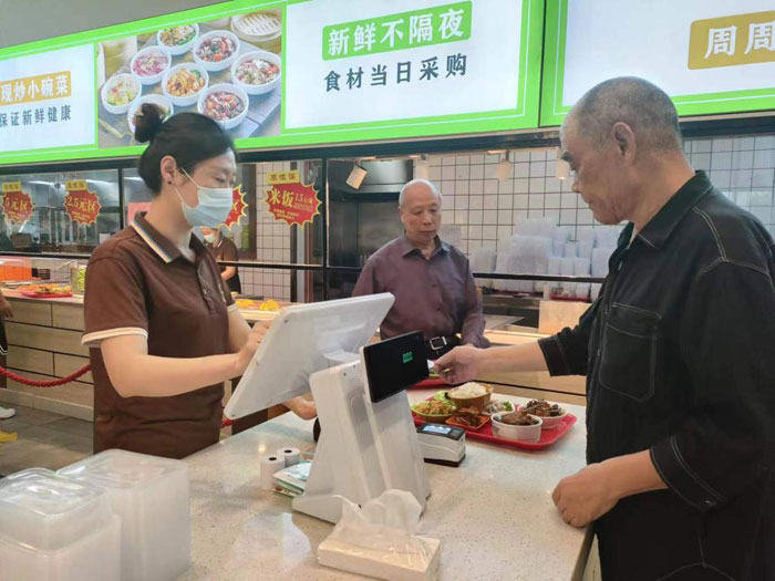 老年居民在铜陵某社区食堂使用助餐服务系统就餐（取餐）。工行安徽省分行供图